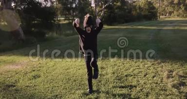 小男孩戴着自制的忍者面具和黑色服装练习忍者动作，忍者，试图在公园里摆出一个姿势